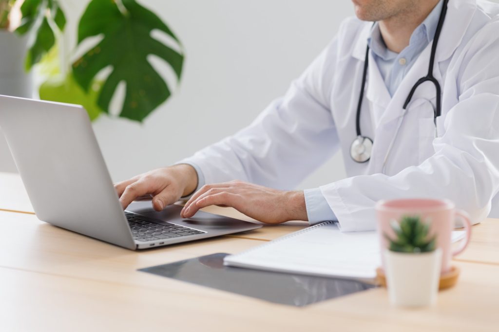 telemedicine, doctor in a white coat and glasses communicates with a patient